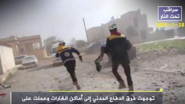 ​Residents and rescuers pick through the rubble of a building in Saraqeb, in Syria's Idlib province, allegedly destroyed by shelling from President Bashar Assad's military 