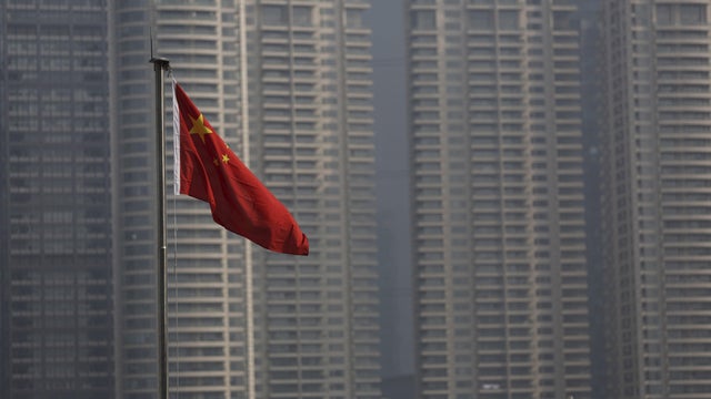 FILE PHOTO: A Chinese flag is seen in front of the financial district of Pudong in Shanghai 