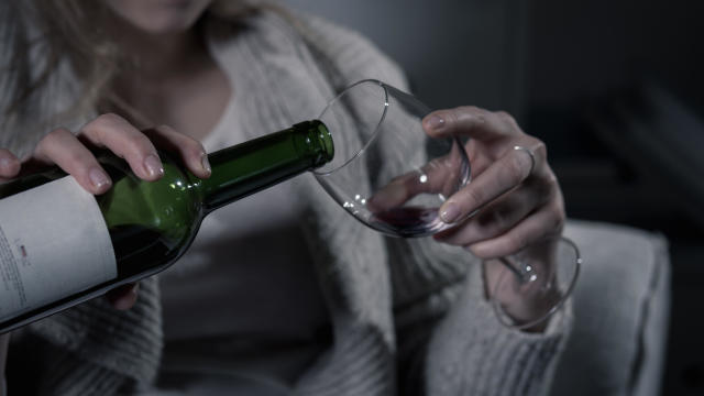 Female hands pouring red wine 