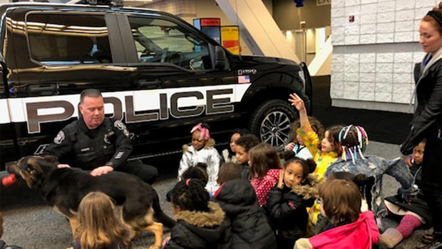 Officer Casey Lockard and his partner Gerix explain to the First Graders of Woolslair School how police vehicles, officers and dogs work together to keep communities safe. 