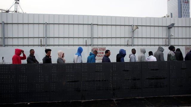 African migrants wait in line for the opening of the Population and Immigration Authority office in Bnei Brak 