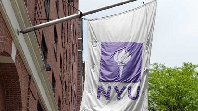 Flags fly from a New York University bui 