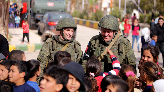 Russian soldiers are seen with Syrian children at Wafideen camp in Damascus 