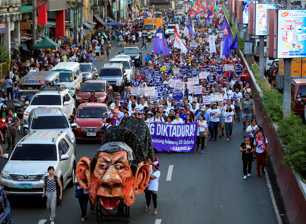 An effigy of Philippine President Rodrigo Duterte is seen while women's rights activists march along a busy street during a celebration of the International Women's Day in Quiapo city, Metro Manila 