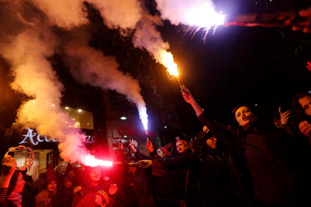 Activists light flares as they march at the main shopping and pedestrian street of Istiklal during a rally on the International Women's Day in Istanbul 