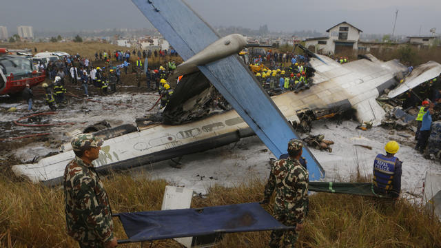 Rescue workers work at the wreckage of a US-Bangla airplane after it crashed at the Tribhuvan International Airport in Kathmandu 