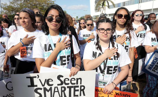 Students listen to the national anthem while rallying in the street during the "March for Our Lives" demanding stricter gun control laws at the Miami Beach Senior High School, in Miami 