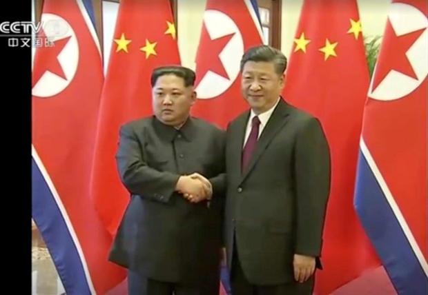 Still image of North Korean leader Kim Jong Un shaking hands with Chinese President Xi Jinping 