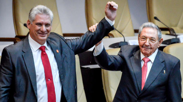 Newly elected Cuban President Miguel Diaz-Canel, left, reacts as former Cuban President Raul Castro raises his hand during the National Assembly in Havana, Cuba, April 19, 2018. 