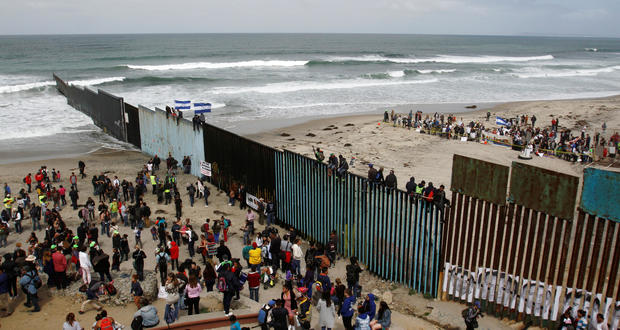 Members of a caravan of migrants from Central America and supporters gather on both sides of the border fence between Mexico and the U.S. as part of a demonstration, prior to preparations for an asylum request in the U.S., in Tijuana 