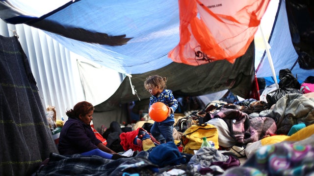 A child traveling with a caravan of migrants from Central America holds a ball at a camp near the San Ysidro checkpoint, after U.S. border authorities allowed the first small group of women and children entry from Mexico overnight, in Tijuana 