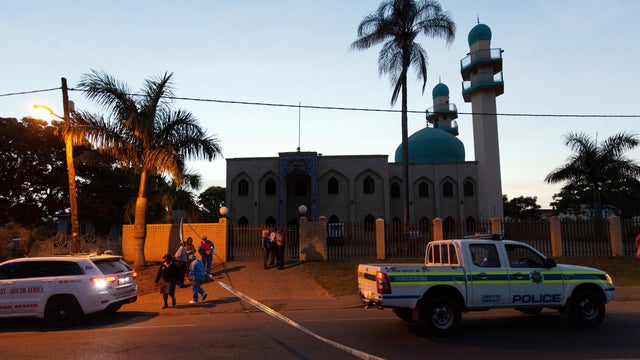 Police investigators collect evidence at a mosque where three men where attacked in Ottawa, South Africa 