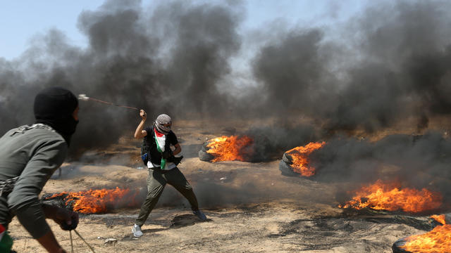 Demonstrator uses a sling to hurl stones at Israeli forces during a protest where Palestinians demand the right to return to their homeland, at the Israel-Gaza border in the southern Gaza Strip 