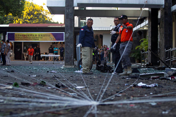 Police forensic team examine the scene of a bomb at a church in Surabaya, East Java 