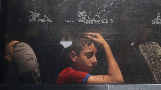 Palestinian boy looks out a bus window as he waits to travel into Egypt through the Rafah border crossing, in the southern Gaza Strip 