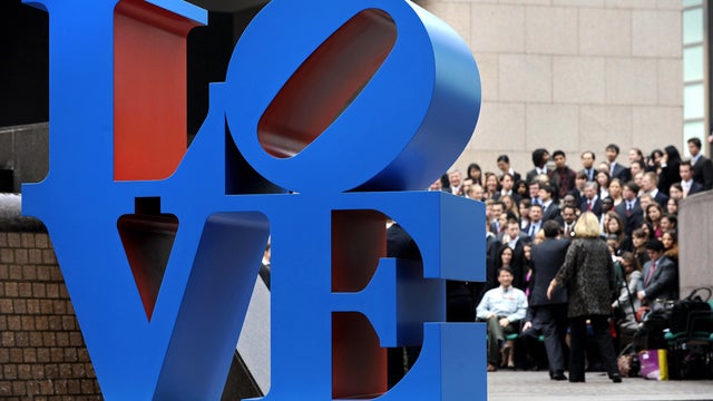 A sculpture by artist Robert Indiana is displayed in a public area in Hong Kong on March 9, 2008, as people gather for a group photo. The sculpture is inspired from Indiana's "Love" painting from the 1960s. 