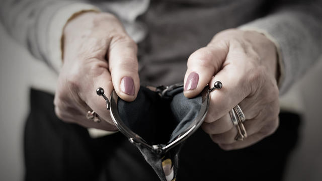 Older person holding money wallet open 