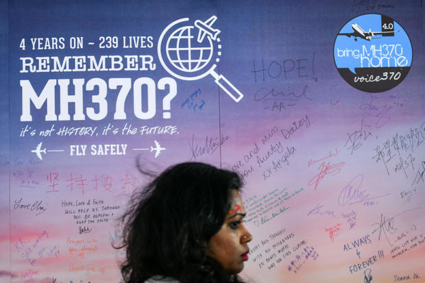 A woman walks past a banner bearing solidarity messages for passengers of the missing Malaysia Airlines Flight 370 during a memorial event in Kuala Lumpur on March 3, 2018, ahead of the fourth anniversary of the ill-fated plane's disappearance. 