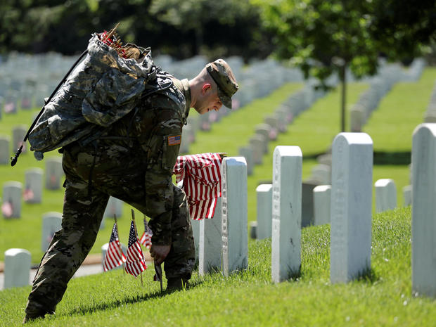 U.S. Army soldiers of the 3rd United States Infantry Regiment arrive to place U.S. flags on graves at Arlington National Cemetery 