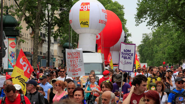 Protesters hold placards during a demonstration by French unions and France Insoumise" (France Unbowed) political party to protest against government reforms, in Paris 