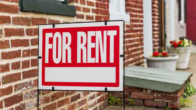 Red For Rent sign closeup against brick building 