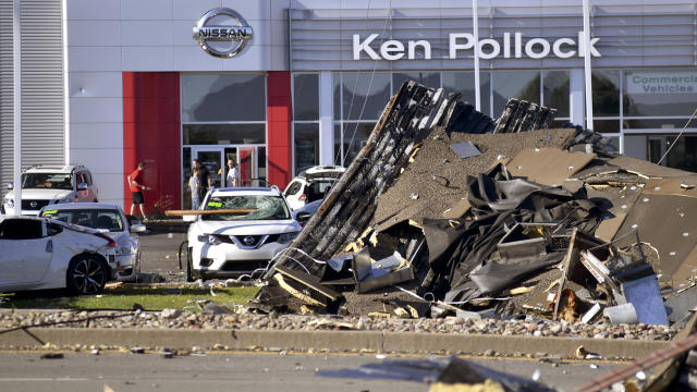 Debris and damaged vehicles sit in front of a car dealership on June 14, 2018, in Wilkes-Barre Township, Pennsylvania. 