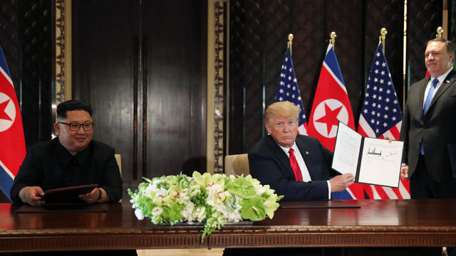 U.S. President Donald Trump shows the document, that he and North Korea's leader Kim Jong Un signed at their summit in Singapore 