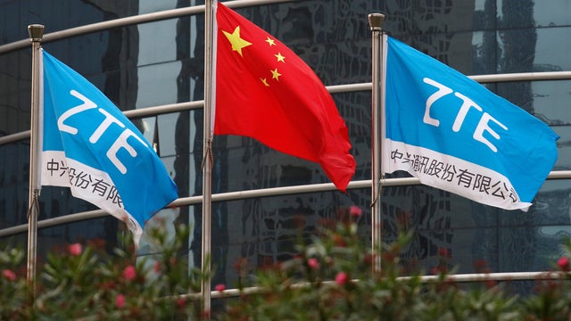 A Chinese national flag and two flags bearing the name of ZTE fly outside the ZTE R&D building in Shenzhen 