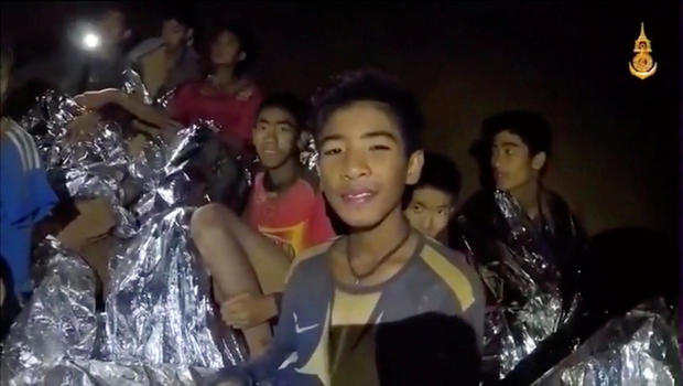 Boys from the under-16 soccer team trapped inside Tham Luang cave covered in hypothermia blankets react to the camera in Chiang Rai, Thailand 