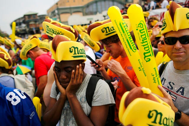 A man covers his ears from noise as people attend the annual Nathan's Famous hot dog eating contest on July 4, 2018, in the Coney Island neighborhood of the Brooklyn borough of New York City. 