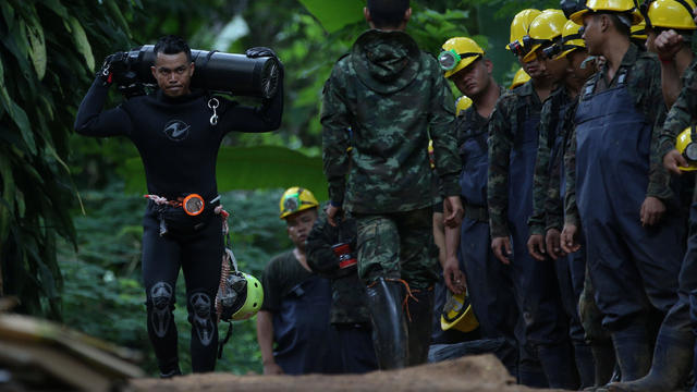 A diver carries an oxygen tank as he leaves the Tham Luang cave complex, where 12 boys and their soccer coach are trapped, in the northern province of Chiang Rai 
