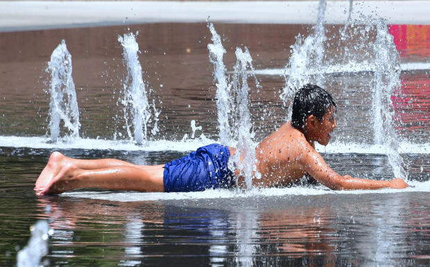 A boy cools off in the water play area at Grand Park in Los Angeles, California, on July 5, 2018, ahead of a heat wave in the Los Angeles area. 
