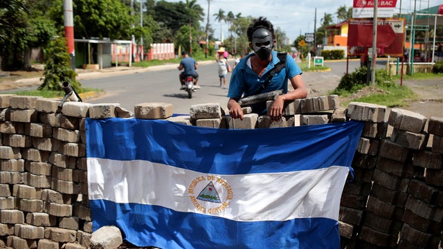 A protester stands at a barricade on the Pan-American highway during a protest against Nicaraguan President Daniel Ortega's government in Jinotepe 