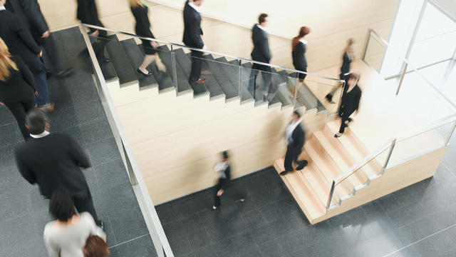 Businesspeople walking down office staircase 