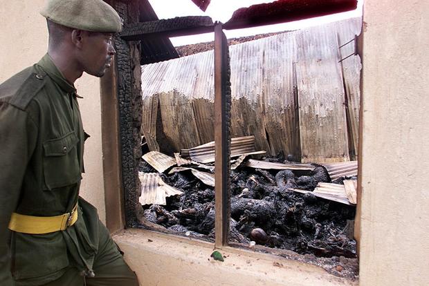 A soldier views the burned remains of up to 250 Ug 