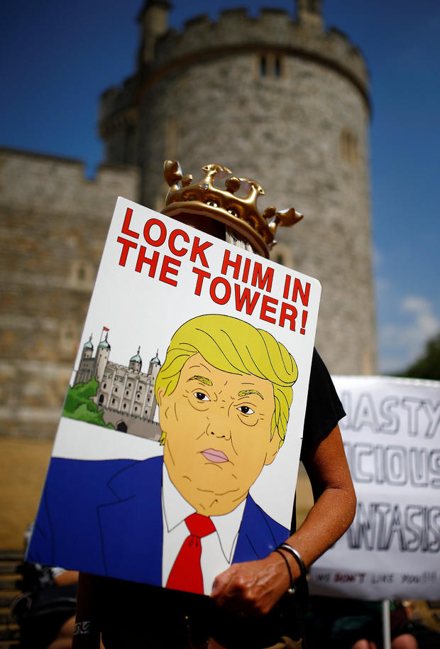 Demonstrators protesting against the visit of U.S. President Donald Trump hold banners, in Windsor 