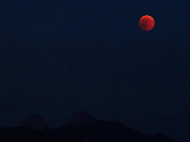 The full moon rises during a total eclipse above the Tour de Mayen and Tour d'Ai in the Swiss Alps in this picture taken from Chardonne 