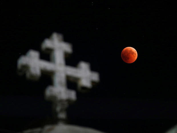 The moon is seen during a lunar eclipse over the Coptic Orthodox Patriarchate Church in Amman 