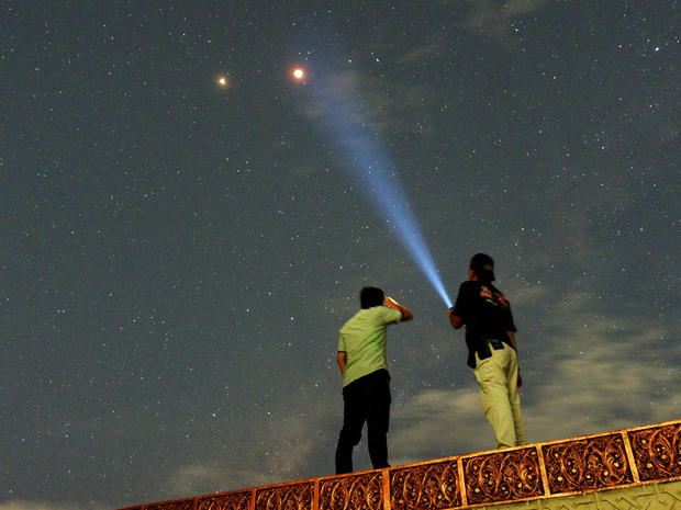 Residents look at Mars alongside the lunar eclipse in Padang 