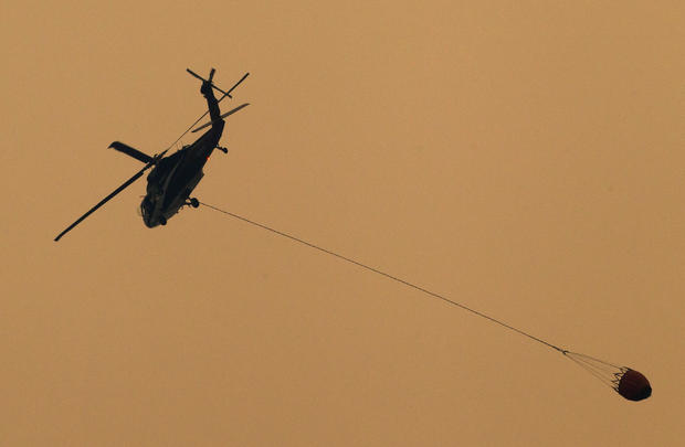 A helicopter prepares to drop water on the Carr Fire as it burns west of Redding 