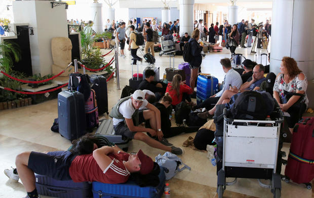 Foreign tourists sit and lie on the floor as they queue to leave Lombok Island after an earthquake hit, as seen at Lombok International Airport, Indonesia 