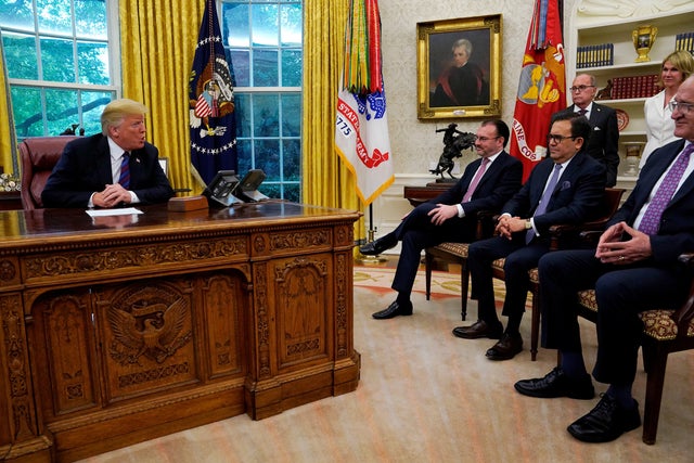 Mexican trade representatives look on as Trump announces deal on NAFTA at the White House in Washington