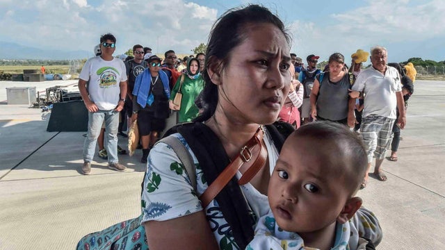 People injured or affected by the earthquake and tsunami wait to be evacuated on an air force plane in Palu, Central Sulawesi 