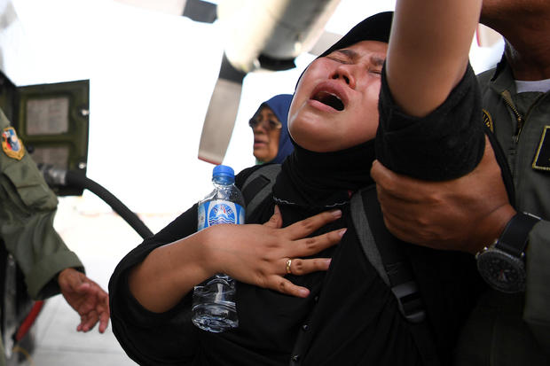 A woman cries as she waits to be evacuated by military aircraft following an earthquake and tsunami at Mutiara Sis Al Jufri Airport in Palu 