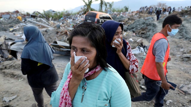 Women react while visiting Petobo neighbourhood which was hit by an earthquake and liquefaction in Palu 
