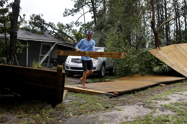 Joseph Howat clears a damaged fence by Hurricane Michael at his business in Panama City Beach 