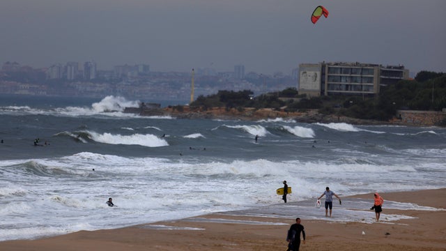 Surfers leave the sea at Carcavelos beach, near Cascais 