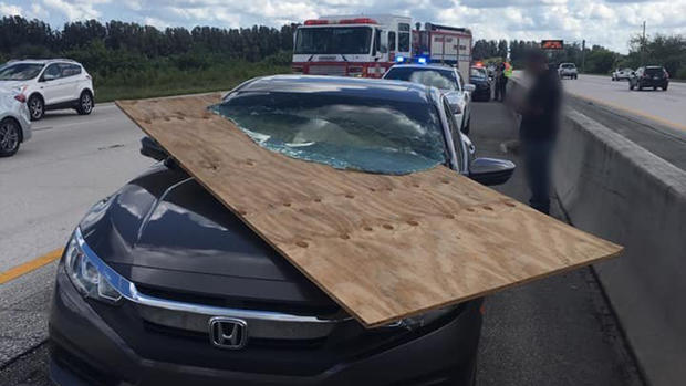 Driver Uninjured After Plywood Slices Through Windshield 