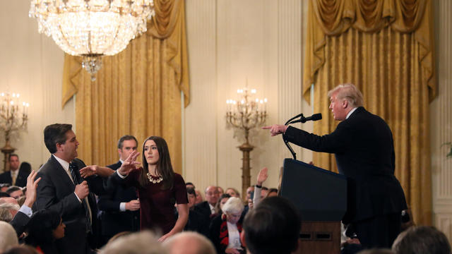 A White House staff member reaches for the microphone held by CNN's Jim Acosta as he questions U.S. President Donald Trump during a news conference in Washington 