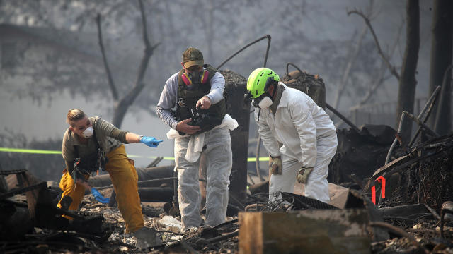 Rescue workers search an area where they discovered suspected human remains in a home destroyed by the Camp Fire on Nov. 16, 2018, in Paradise, California. 